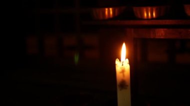 close up minimal view to the candle stick with fire light for praying blessed wish in dark room ,buddhism religion background concept