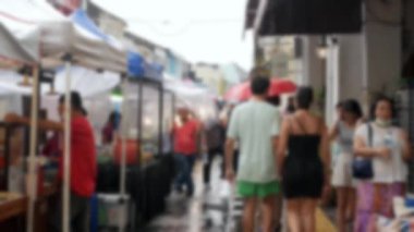 Out of focus blurred of shoppers shopping in walking street through Asian street market in thalang road, old town, phuket thailand, background video