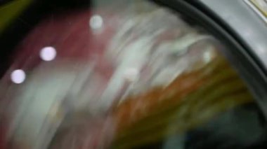 close up to washing machine washes laundry colored clothing and sheets washing machine and dryer working at professional industrial laundry