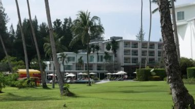 November 27,2022:Phuket,Thailand:landscape of resort hotel building among green grass lawn and coconut palm trees at Panwa beach in Phuket under summer vacation holiday daytime