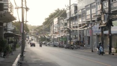 June13,2022.Phuket,Thailand. street view in phuket town in early morning with sunrise shining and some traffic