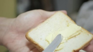 closeup video spread fresh butter on the toasted sliced bread for breakfast healthy meal. Southeast asia breakfast life