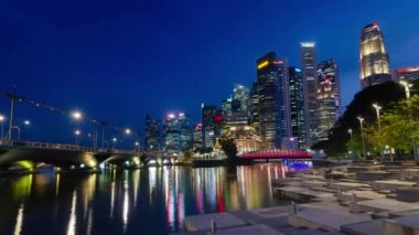 Singapur şehrinin, Singapur 'un sinsi zaman çizelgesi arka planında Singapur Nehri ve halka açık alanı olan marina körfezi çevresindeki yüksek gökdelen binasıyla günbatımı zamanı.