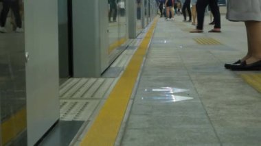 Trenin toplu taşıma platformuna ayak görüntüsü. Birçok yolcu trene binmek için bekliyor, Angkok pulic skytrain taşımacılığı.