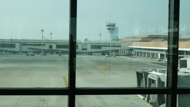 昼間の空港ターミナルの窓から飛行機の駐車場 交通機関の背景コンセプトを見る — ストック動画