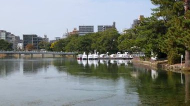 Japonya, Hakata, Fukuoka 'daki Ohori halk parkındaki göl gölünün doğal manzara manzarası. Sonbahar günü açık mavi gökyüzü altında ve şehir yatay hat üzerinde.