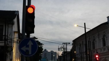 Phuket 'in eski kasabasının kavşağındaki trafik ışığına bakın. Puket antik şehrinin koloni mimari binasının arka plan görüşü ve alacakaranlık gökyüzü.
