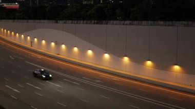 Gün batımında büyük bir şehirde karayolu caddesinde çok sayıda trafik arabası bulunan karayolu trafiğine doğrudan tepeden bak. Singapur 'un şehir merkezindeki Singapur iş merkezi bölgesinde ulaşım.