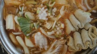 Domuz eti, mürekkep balığı, midye, ehmook balık tabağı ve sebzeyle dolu Kore kimchi tteok pokki çorbasına yakın bir yerde. Asain Kore geleneksel yemekleri