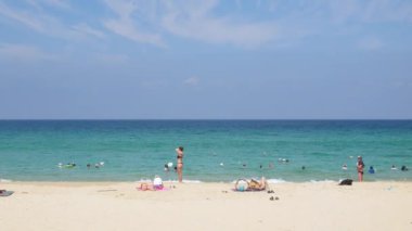 Nisan 6.2023.Phuket, Tayland. İnsanlar yaz tatillerinde tatil yaparken dinleniyorlar. Tropik bir ada olan Phuket 'te beyaz kumsal kenarında, güneşli bir günde güneşli bir günde 4K video görüntülerinde.