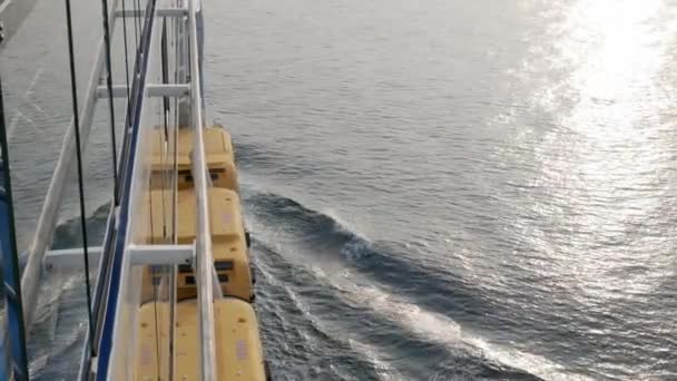 大型游轮上的救生艇在海面上俯瞰 当它在海里航行时 海浪在海面以下 安全的集合救生艇设备 暑假背景 — 图库视频影像
