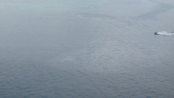 透明度の高い緑の海の中で美しい白い泡の波を作るパトンベイエリアでジェットスキーアクションエクストリームウォータースポーツをしている人々と海への眺め — ストック動画