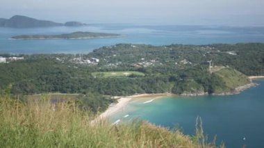 Yaz tatilinde tropikal okyanus denizi ve güneş ışığı altındaki adaların güzel doğal manzaralı deniz kıyısı manzarası yeşil çimen tarlası, Phuket, Tayland 'daki siyah kaya manzarası