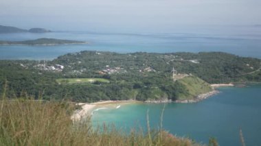 Yaz tatilinde tropikal okyanus denizi ve güneş ışığı altındaki adaların güzel doğal manzaralı deniz kıyısı manzarası yeşil çimen tarlası, Phuket, Tayland 'daki siyah kaya manzarası