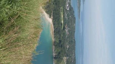 Yaz tatilinde güneş ışığı altındaki tropikal okyanus ve adaların güzel doğal manzaralı deniz kıyısı manzarası yeşil çimen tarlası, Pofet, Tayland 'da siyah kaya manzarası