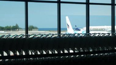 9 Şubat 2023.Phuket, Tayland. Uçak park alanında yoğun saatlerde çalışan uçaklarla iç kalkış terminalinden dışarıya manzara.