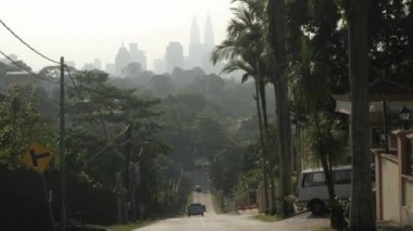 view local street leads into the downtown city center of Kuala lumpur in Malaysia with modern skyscraper building financial district and sunrise in the sky, KL city from hill