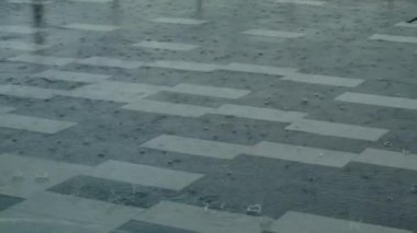 Heavy rain drops falling on city asphalt floor tiles during a heavy thunderstorm.rain water drops falling on asphalt flooding the walkway path street.Road floods due to the heavy rain in wet season.
