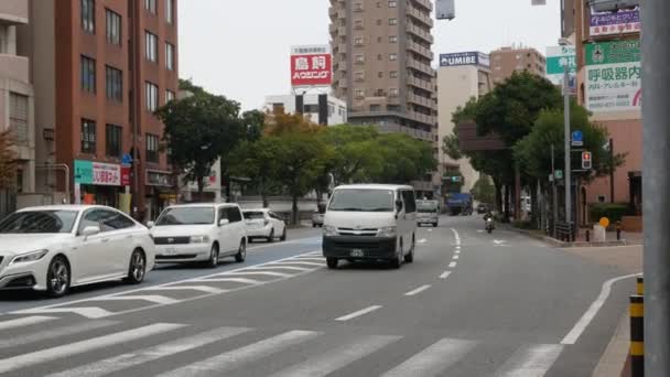 広告看板や看板を持つ近代的な建物の中で 福岡の昼間のInfujisakiエリアの間に車や人々の交通 日本のストリートビュー — ストック動画