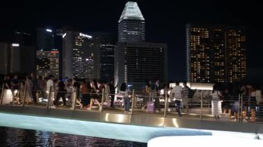 26 Nisan 2023. Singapore. marina körfezi bölgesinde birçok turist ve Singapur Metropolitan 'daki gökdelen işletme finans binasının arka planına gece vakti bakın.
