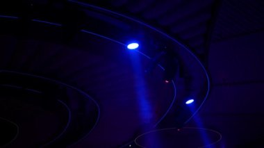 Soyut flaşlı sahne ışığı, sahne ışığı, disko ışığı. Parlak sahne ışıkları, siyah arka plandaki mavi, yumuşak ışık vuruşunda hareket eğlencesi yanıp sönüyor..