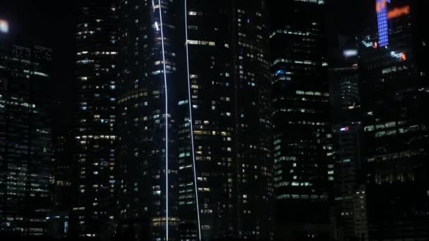 近代的なオフィスは 都市ビジネス地区の高層ビルの金融ビルを夜間照明で高層化します 4K現代都市で空まで近代的なガラス金融近代的な建物を見上げます — ストック動画