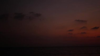 Günbatımında okyanus denizi üzerindeki vanilya gökyüzünün güzel manzarası. Gün batımında tam gün ışığı kabarık bulutların üzerinde parlıyor. Sarı turuncu ve pembe renkler gökyüzünde günbatımı güzel arka planda gökyüzü