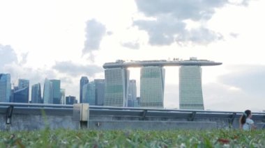 Mayıs 2023. Singapore. marina baraj bölgesindeki yeşillik çimenliğine bakın. Tatilde piknik yapan birçok insan Singapur 'un merkez iş bölgesindeki tarihi yapıların arka planında dinleniyor.