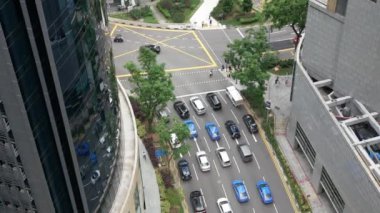 Singapur Şehri şehir merkezindeki trafik caddelerinin yukarıdan görünüşü. Sokakta hava manzaralı bir sürü otobüs var. Trafik sokağının kesiştiği saatte yukarıdan aşağıya doğru manzara