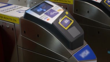 Trafik saatinde metro istasyonunun otomatik bağlantısız girişine bakın. Bir adam geçitten geçerken, metro bilet kontrol paneli yeşil ışıklarla, insanlar dokunmadan girmek için para ödüyor.