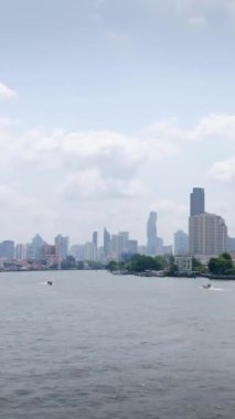 Chaopraya Nehri 'nin dikey zaman çizelgesi. Nehir suyu taşımacılığı ve Bangkok şehrinin arka planı. Gündüz vakti merkez bölge arasında birçok gökdelen var.