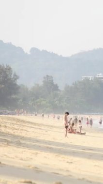 6 Nisan 2023.Phuket, Tayland. Yaz tatili sırasında Karon, Phuket 'teki tropik plajda güneşlenen kalabalık insanların dikey zaman çizelgesi. Yaz güneşi altında plajda tatil yapan insanlar.