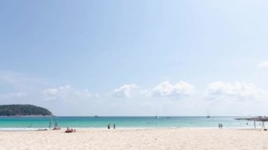 6 Nisan 2023.Phuket, Tayland. Zaman dilimi. Yaz Tatili sırasında kalabalık insanların Naiharn Plajı 'ndaki tropikal plajda güneşlendiği 4k video. Yaz günlerinde plajda tatil yapan insanlar.