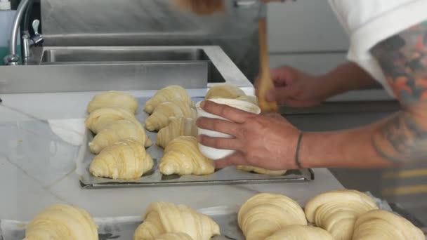 Опытный Пекарь Покрывающий Свежеприготовленное Круассановое Тесто Яичной Смесью Перед Выпечкой — стоковое видео