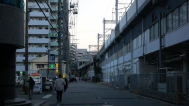 17 Kasım 2022 Fukuoka, Japon sokak manzaralı arabalar ve insanlar gündüz Hakata, Fukuoka 'da JR tren yolu yakınlarındaki modern binalar, Japonya' daki sokak manzaralı