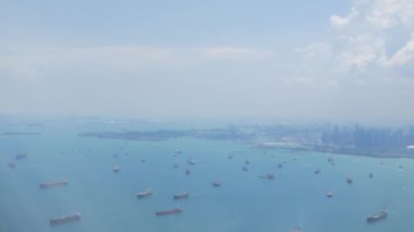 Singapur Körfezi Limanı 'nın yukarıdan görünüşü uçaktan Singapur' a inmeye hazırken. Singapur limanının gündüz hava görüntüsü ve denizde birçok konteynır yolcu gemisi var.