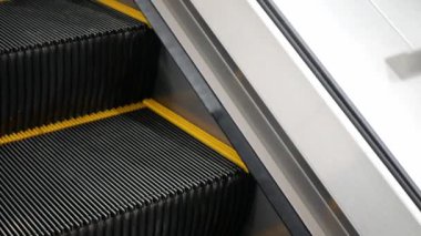 Metro metro istasyonunda ya da havalimanı toplu taşımacılığında merdivenleri çıkarken merdiveni kapat, yürüyen merdiven teknolojisi arka planda. Kapalı alanda hareket eden modern yürüyen merdiven.