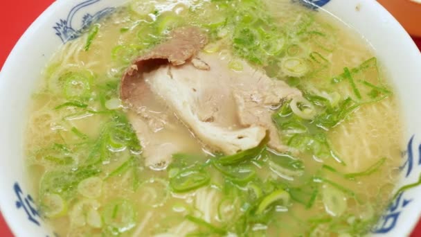 スライスした玉ねぎでスライスした豚肉を使ったトンコツソースラーメン 中国の麺 日本のラーメンボールホットスープ — ストック動画