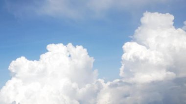 Güneşli bir günde bulutların üzerinde uçuşan beyaz kabarık bulutlu mavi gökyüzü sıcak havada yazın atmosferde hareket eden bulutlarla birlikte. yaz bulutları arka planı