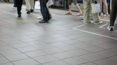 Kalabalık insanlar kalabalık saatlerde Tayvan 'da toplu taşıma, metro taşımacılığı ve şehir yaşamında yürürken metro istasyonundaki platforma alçak açılı bakış açısı