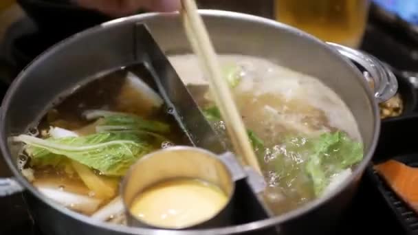 熱い鍋のスープで煮込むために肉球を置いている間 野菜の多くの種類のホットポット シェブの近く 日本のアジアのおいしい健康なホットポットシェブレストラン — ストック動画