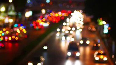 Gece vakti yola çıkan trafik ve bokeh ışıklarıyla otoyol jeti odak alanının dışında, aydınlık arka planlı astrakt trafik manzarası