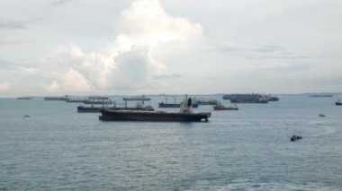 Marina Bay Singapur liman bölgesinin hava manzarası gündüz denizde birçok yolcu gemisi ve konteynır kargo gemisiyle Singapur limanının en işlek limanında kargo teslimat gemisi.
