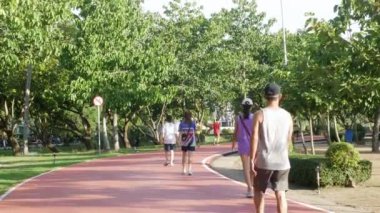 15 Haziran 2023.Phuket, Tayland. Gün batımında Phuket şehir merkezindeki ünlü halk parkı Suanluang Parkı 'ndaki koşu pistinde koşan insanların manzarası.