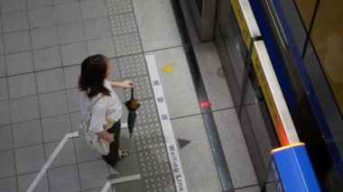 27 Temmuz 2023.Taipei, Tayvan. Metro istasyonunda iş çıkış saatinde trene binmeye hazır yolcuların üst görüntüsü. Şehir toplu taşımacılığı.