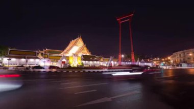 4k Timelapse caddesi manzarası ve Wat Suthat tapınağında gece trafiği. Miras alanı üzerinde ışık süslemesi olan tapınak. Bangkok, Tayland 'daki ünlü Pwararam tapınağının manzarası.