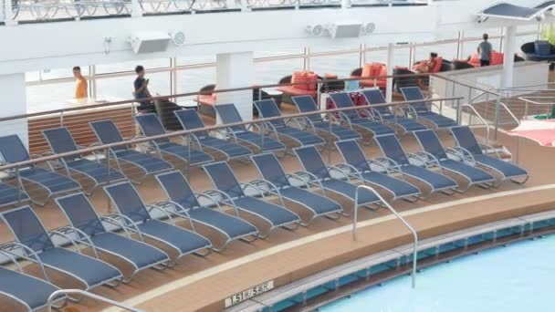 4月30 20233 夏休みの休暇中にいくつかの乗客とクルーズ船の日没のラウンジチェア プールの隣にあるバルコニーデッキのサンラウンジチェア — ストック動画