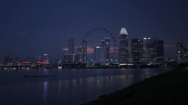 Singapur ufuk çizgisi şehir Singapur nehrinin kıyısında modern ofis gökdelenleri ile gökdelen finans binaları ile merkezi iş bölgesinde geceleri yıldırımlı. Modern cam binalar.
