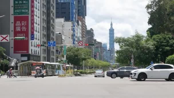 台北市 与大楼和台北101高楼灯标环绕的行人和汽车交通交界处的街景 — 图库视频影像