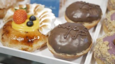 Vitrindeki tatlı çörekçi dükkanındaki ev yapımı donut çöreği vitrinine bakın. Lezzetli çörekler için, fast food sağlıksız tatlı atıştırmalıklar ama lezzetli görünüyor.